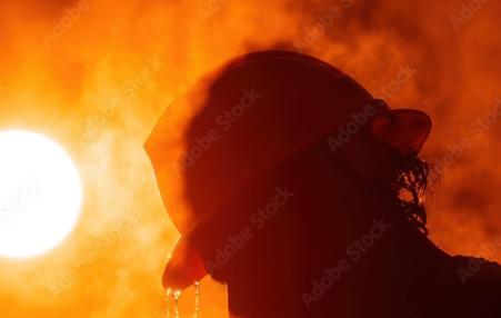Image of a man's head with a hard hat and a hot sun.