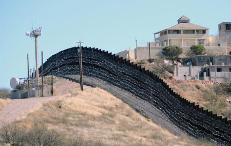 intimidating border wall with barbed wire covering