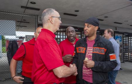 Photo of UAW president handshaking and talking to a worker.rkesr