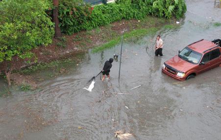 People try to pass through a flooded street in Miami Beach. 