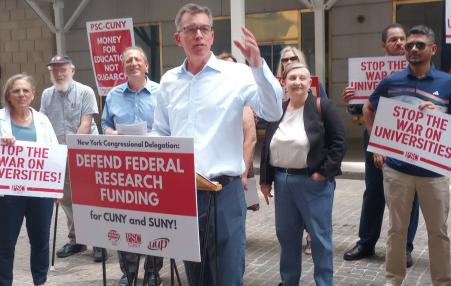 President of PSC and other members rally with signs saying "stop the war of universities". th