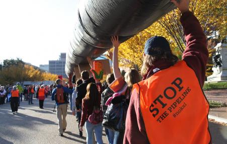 Keystone XL protesters carry a replica pipeline. 