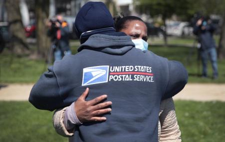 Annette Clay gets a hug from a postal worker during a ceremony honoring her daughter Unique Clay. 