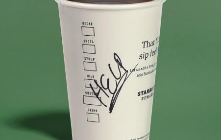 Photo of a Starbucks coffee cup with HELP written across it. 