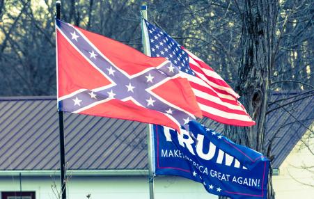 The Confederate Flag, the US Flag, and a Donald Trump flag. 