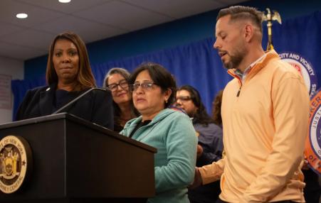 Photo of workers speaking at a press conference with Tish James in the background. 