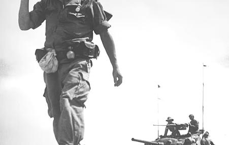 French soldier on foot in Vietnam in front of a U.S.-supplied tank