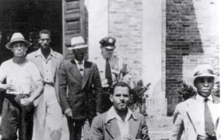 5 arrested demonstrators being escorted out of a Jim-Crow library