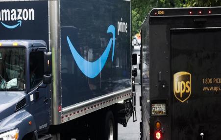 Photo of an Amazon truck next to a UPS truck. 
