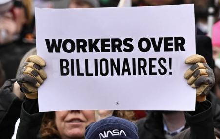 A person holds up a sign as they protest against U.S. President Donald Trump and Elon Musk's Department of Government Efficiency  A person holds up a sign as they protest against U.S. President Donald Trump and Elon Musk's Department of Government Efficiency (DOGE) in Washington, D.C. on February 5, 2025. (Photo: Drew Angerer/AFP via Getty Images)