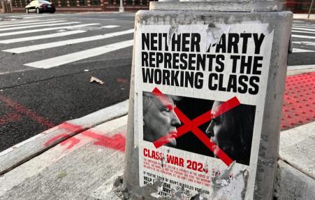 photo of a weather-worn and tattered poster on the street that says Neither Party Represents the Working Class.