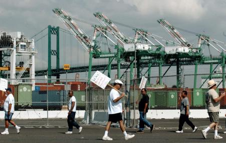 Workers with signs picketing along the dock.
