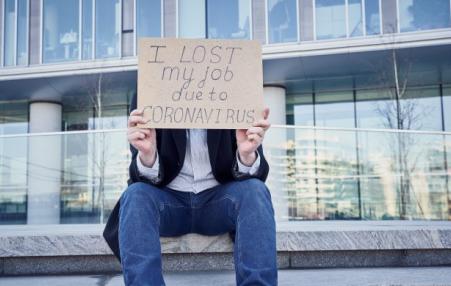 A worker holds a sign saying,” I lost my job due to Coronavirus.” 