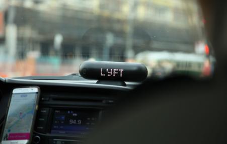 photo from inside a car with a sign LYFT atop the dash board 