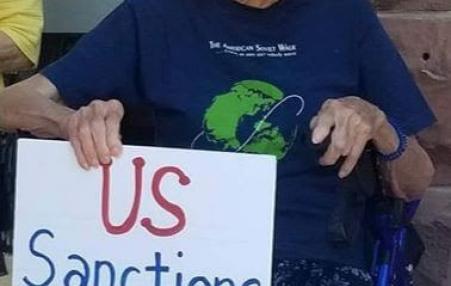 older woman holding protest sign