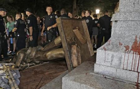 Police stand guard after Silent Sam was toppled at the University of North Carolina on Monday.