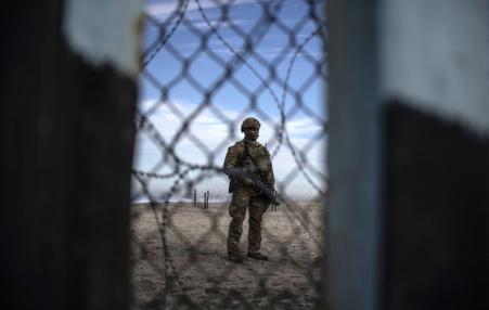 Armed US soldier standing at border with Mexico