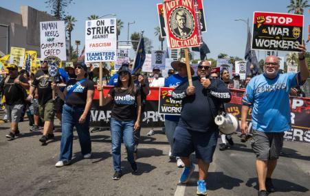 Photo at the front of a march going forward with signs reading Teamsters against fascism.